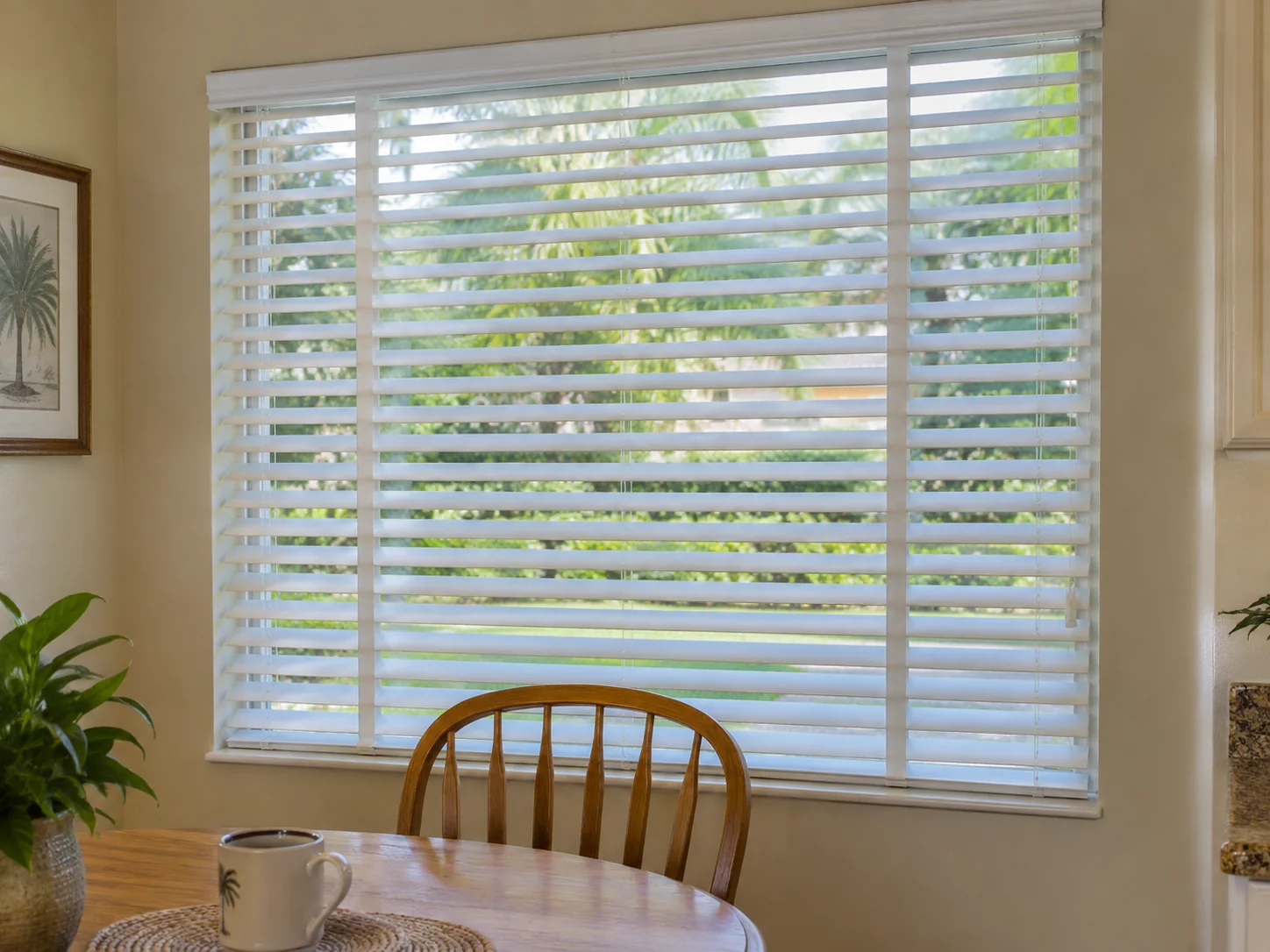 White horizontal blinds filtering daylight in a breakfast nook